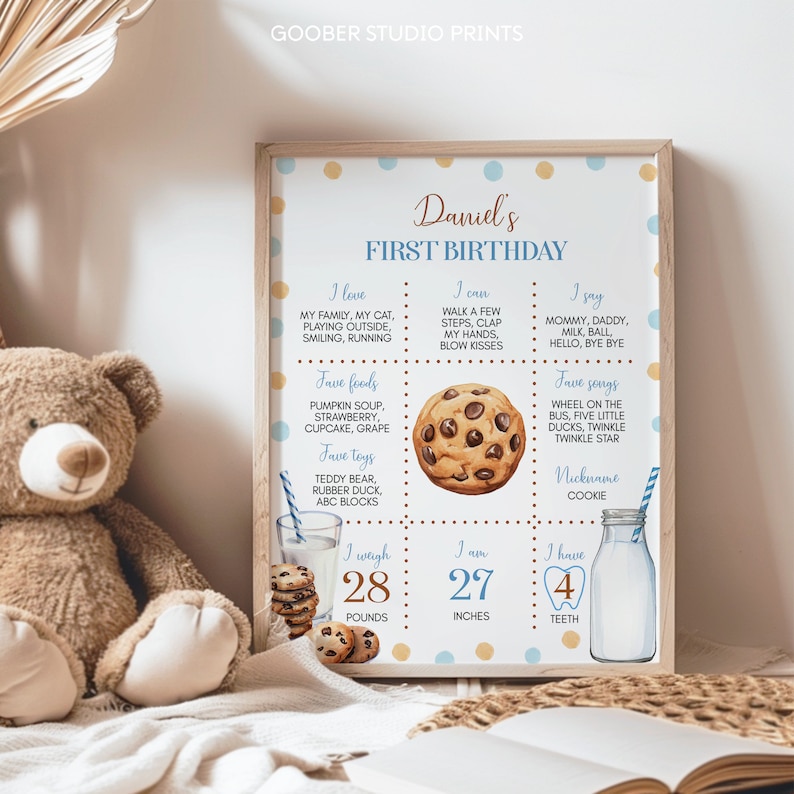 May include: A blue and yellow printable first birthday chart for a baby boy named Daniel. The chart includes information about the baby's favorite foods, toys, songs, and what he can do. It also includes his weight, height, and number of teeth. The chart is decorated with a cookie illustration.