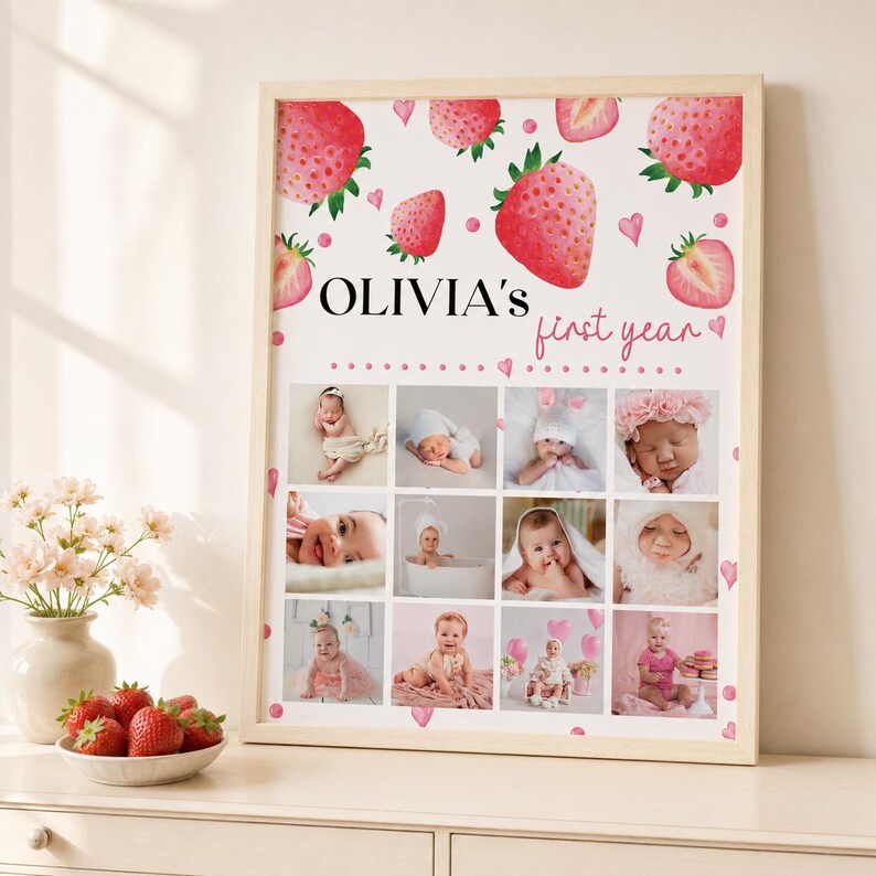 K&ouml;nnte beinhalten: Ein rechteckiger Wandkunstdruck in einem hellen Holzrahmen mit wei&szlig;em Hintergrund, Aquarell-Erdbeerillustrationen und dem Text "OLIVIA'S first year". Unter dem Text befinden sich zw&ouml;lf quadratische Fotofelder mit verschiedenen Babyportr&auml;ts.