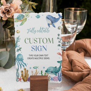 May include: A white sign with a blue and green ocean theme. The sign says "Fully editable CUSTOM SIGN" and "Type your own text. Create multiple signs."