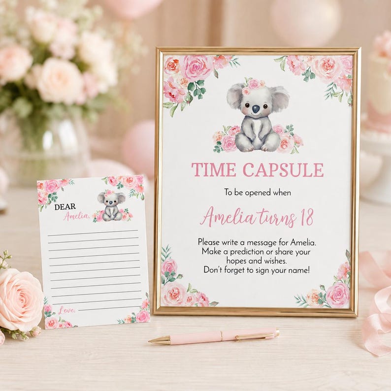 K&ouml;nnte beinhalten: Ein goldgerahmtes Schild und eine passende Karte mit einer Koala-Illustration und rosa Rosen. Das Schild tr&auml;gt die Aufschrift: TIME CAPSULE To be opened when Amelia turns 18. Please write a message for Amelia. Make a prediction or share your hopes.