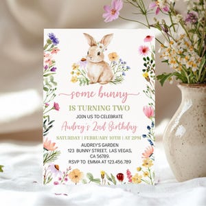 K&ouml;nnte beinhalten: Eine rechteckige Geburtstagseinladungskarte mit einer Aquarellillustration eines braunen Hasen, umgeben von bunten Wildblumen. Der Text lautet: some bunny IS TURNING TWO JOIN US TO CELEBRATE Audrey's 2nd Birthday SATURDAY | FEBRUARY 10TH | AT 2PM AUDREY'S GARDEN 123 BUNNY STREET, LAS VEGAS, CA 56789. RSVP TO EMMA AT 123.456.789