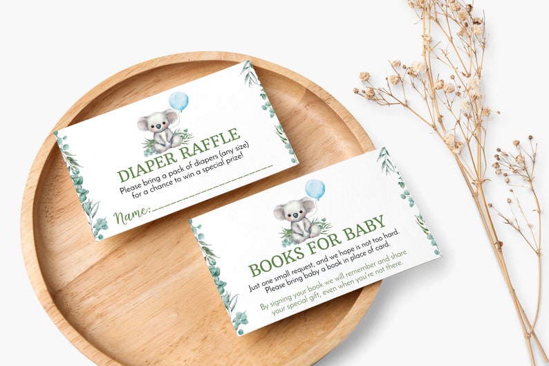 K&ouml;nnte beinhalten: Zwei rechteckige wei&szlig;e Karten mit einem Aquarell-Koala, der einen blauen Ballon h&auml;lt, gr&uuml;nen Eukalyptusbl&auml;ttern und Text. Eine Karte zeigt DIAPER RAFFLE und die andere BOOKS FOR BABY, inklusive gedruckter Anweisungen und einer Zeile f&uuml;r einen Namen.
