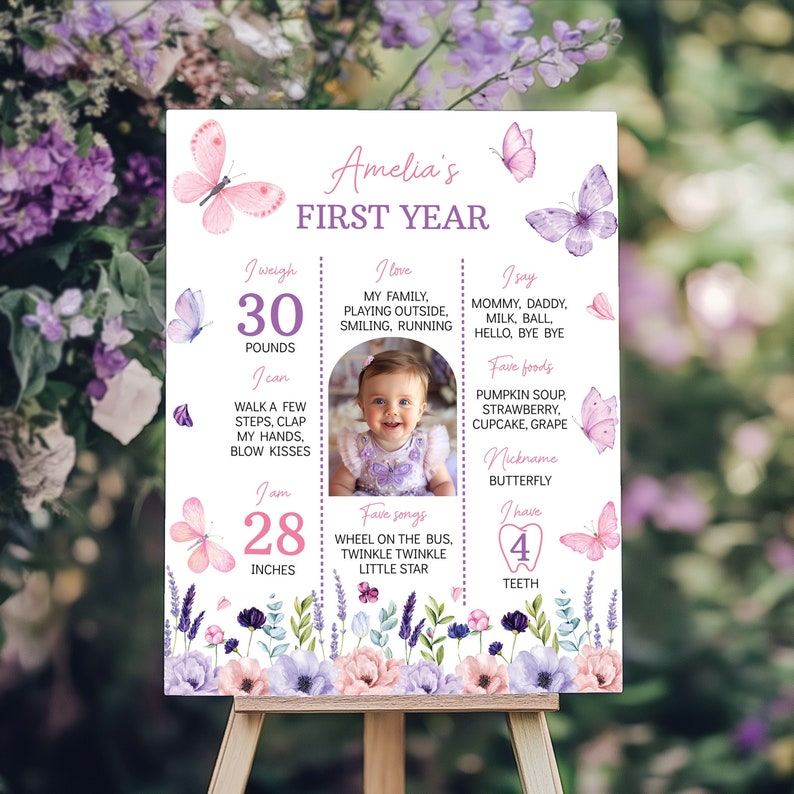 Puede incluir: Un cartel de primer cumplea&ntilde;os rosa y morado con una foto de una ni&ntilde;a. El cartel presenta mariposas, flores y texto que dice "Amelia's First Year" e incluye detalles sobre la edad, el peso, la altura y otros hitos de la ni&ntilde;a.