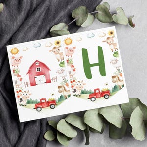 May include: Two white pennant flags featuring watercolour farm illustrations. One flag displays a red barn, a red truck, and various farm animals including a pig, sheep, cow, and horse. The other flag features a large green letter H and a red truck.