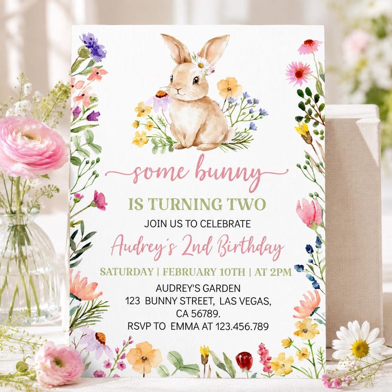 K&ouml;nnte beinhalten: Eine wei&szlig;e, rechteckige Geburtstagseinladungskarte mit einer Aquarellillustration eines braunen Hasen, umgeben von bunten Wildblumen. Der Text lautet: some bunny IS TURNING TWO JOIN US TO CELEBRATE Audrey's 2nd Birthday SATURDAY | FEBRUARY 10TH | AT 2PM AUDREY'S GARDEN 123 BUNNY STREET, LAS VEGAS, CA 56789. RSVP TO EMMA AT 123.456.789.