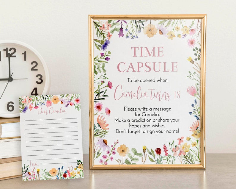 May include: A gold-framed sign and a matching card featuring watercolor wildflowers. The sign reads: TIME CAPSULE To be opened when Camelia turns 18. Please write a message for Camelia. Make a prediction or share your hopes and wishes. Don't forget to sign your name!