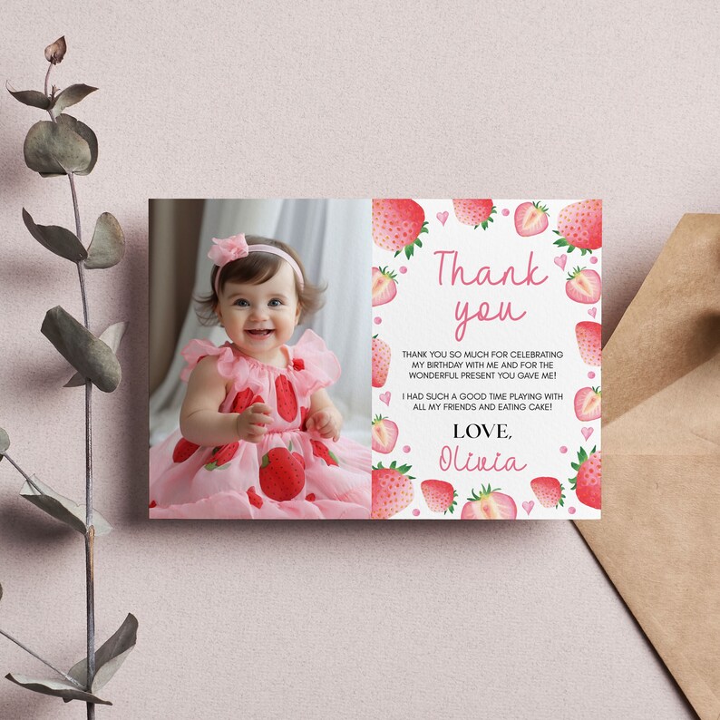 May include: A rectangular thank you card featuring a photograph of a smiling child in a strawberry-patterned dress on the left and watercolor strawberries with pink hearts on the right. The text reads: Thank you, Thank you so much for celebrating my birthday with me and for the wonderful present you gave me! I had such a good time playing with all my friends and eating cake! Love, Olivia.