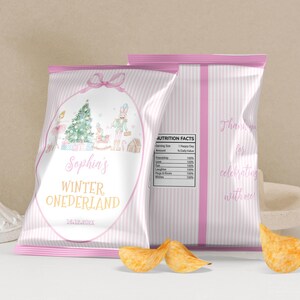 May include: Two custom chip bags with light pink vertical stripes. The front features a watercolor illustration of a Christmas tree, nutcracker, and ballerina, with the text Sophia's WINTER ONEDERLAND and 16.12.2021. The back shows a nutrition facts label.