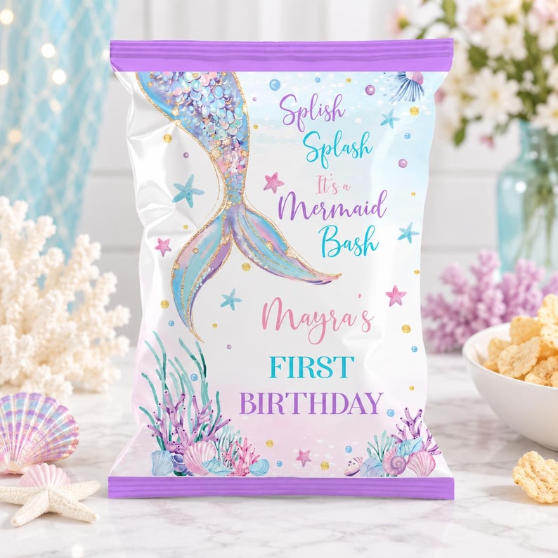 May include: A rectangular snack bag with a purple top and bottom border, featuring a mermaid tail illustration, colorful seashells, and coral. The text reads: Splish Splash It's a Mermaid Bash Mayra's FIRST BIRTHDAY in purple and teal script.