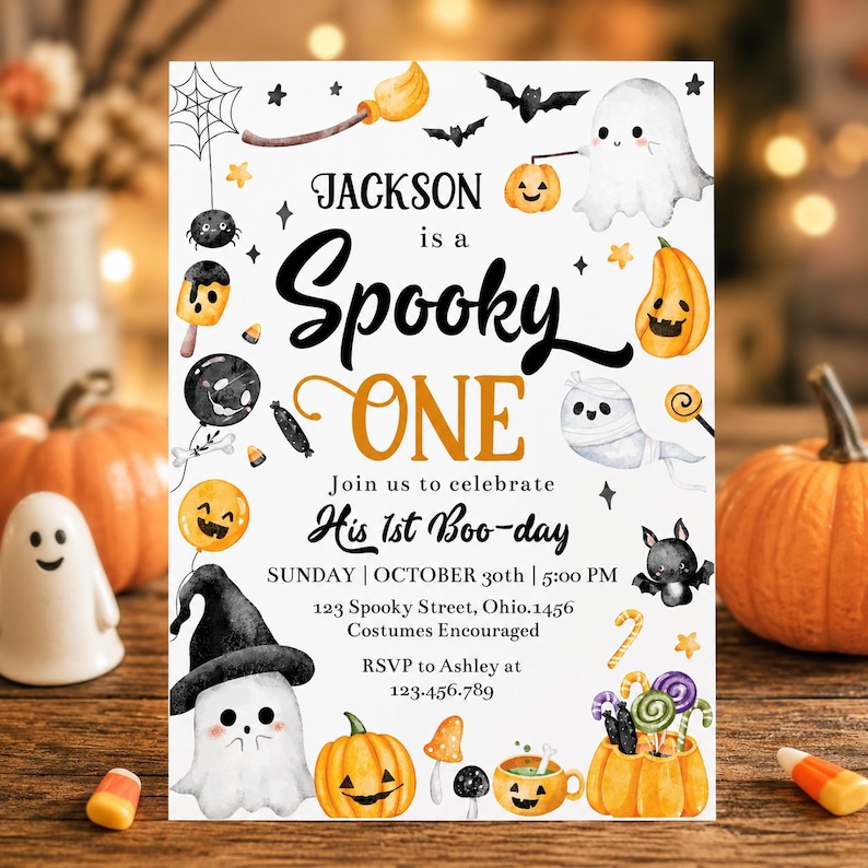 May include: A white Halloween-themed birthday invitation card featuring watercolor illustrations of ghosts, pumpkins, bats, and candy. The text reads Jackson is a Spooky ONE, Join us to celebrate His 1st Boo-day, Sunday, October 30th, 5:00 PM, 123 Spooky Street, Ohio.