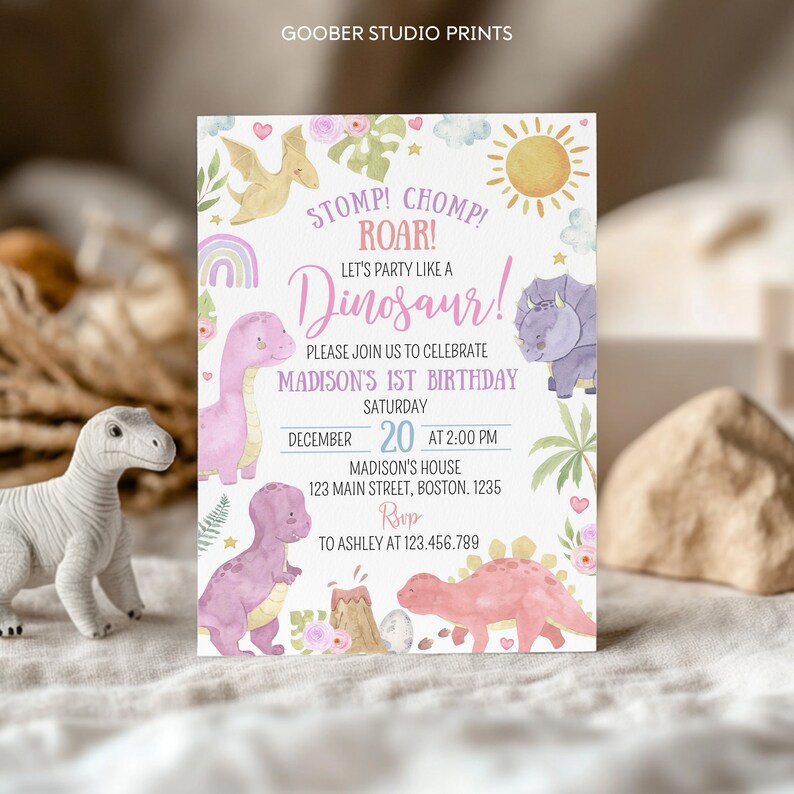 May include: A rectangular birthday invitation card featuring watercolor illustrations of dinosaurs, a sun, a rainbow, and flowers. The text reads: STOMP! CHOMP! ROAR! LET'S PARTY LIKE A DINOSAUR! PLEASE JOIN US TO CELEBRATE MADISON'S 1ST BIRTHDAY.