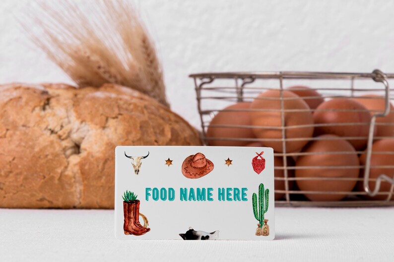 K&ouml;nnte beinhalten: Eine rechteckige wei&szlig;e Karte mit dem Text FOOD NAME HERE in t&uuml;rkisfarbenen Buchstaben. Die Karte ist mit Illustrationen eines Kuhsch&auml;dels, eines braunen Cowboyhuts, eines roten Bandanas, eines braunen Stiefels mit Sukkulente und einer Katze verziert.