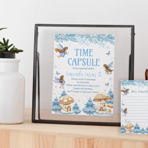 May include: A time capsule sign and matching card featuring blue fairy illustrations, mushroom houses, and pine trees. The sign reads: Time Capsule, To be opened when Amanda turns 18. Please write a message for Amanda. Make a prediction or share your hopes and wishes. Don't forget to sign your name!