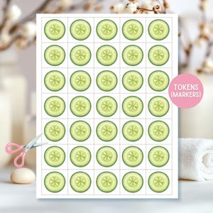 May include: A sheet of paper with 30 cucumber slice tokens, each with a green exterior and a star-shaped center. The text "TOKENS (MARKERS)" is in a pink circle. Pink scissors and a white towel are in the background.
