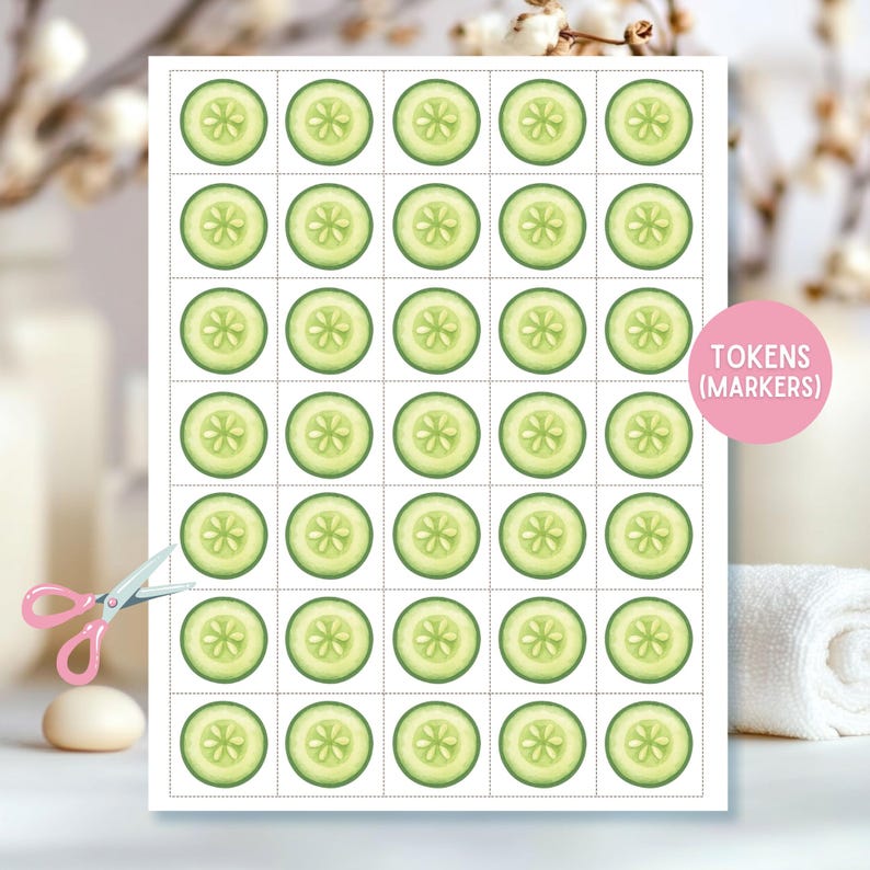 May include: A sheet of paper with 30 cucumber slice tokens, each with a green exterior and a star-shaped center. The text "TOKENS (MARKERS)" is in a pink circle. Pink scissors and a white towel are in the background.