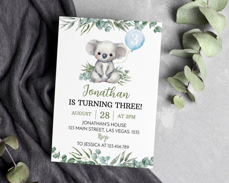 May include: A white rectangular birthday invitation card featuring a watercolor illustration of a koala holding a blue balloon with the number 3. The text reads: Jonathan IS TURNING THREE! AUGUST 28 AT 2PM JONATHAN'S HOUSE 123 MAIN STREET, LAS VEGAS. 1235 RSVP TO JESSICA AT 123.456.789.