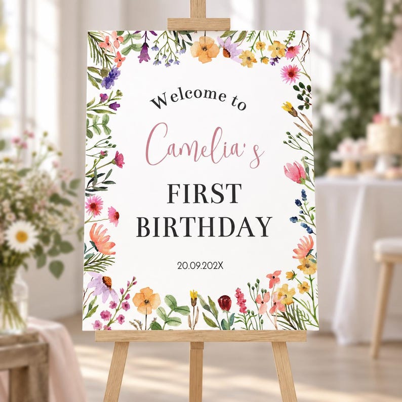 K&ouml;nnte beinhalten: Ein rechteckiges wei&szlig;es Schild auf einer Holzstaffelei mit einem Aquarell-Blumenrand aus rosa, orangefarbenen, gelben und violetten Bl&uuml;ten. Der Text lautet Welcome to Camelia's FIRST BIRTHDAY 20.09.202X in schwarzen und rosa Schriftarten.