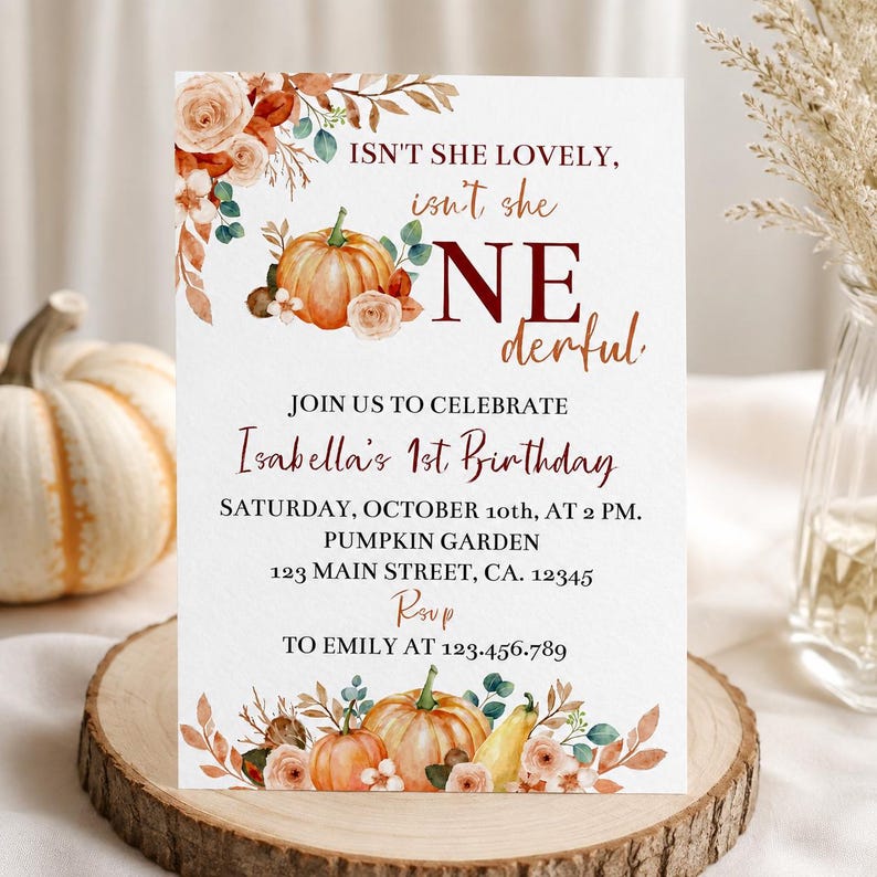 May include: A rectangular birthday invitation card featuring watercolour illustrations of orange pumpkins, autumn leaves, and beige roses. The text reads: ISN'T SHE LOVELY, isn't she ONEderful. JOIN US TO CELEBRATE Isabella's 1st Birthday, OCTOBER 10th, AT 2 PM.