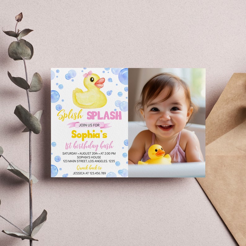 以下が含まれることがあります： ピンクのリボンをつけた黄色いラバーダック、青い泡、そしてSplish SPLASH JOIN US FOR Sophia's 1st birthday bashという文字が印刷された長方形の誕生日招待状。イベントの詳細と浴槽に入った子供の写真が含まれています。