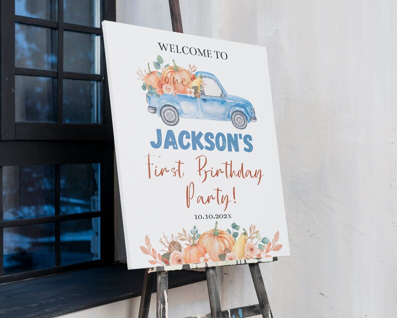 May include: A white rectangular birthday sign featuring a watercolour illustration of a blue pickup truck carrying pumpkins and flowers. The text reads: WELCOME TO one JACKSON'S First Birthday Party! 10.10.202X. The bottom features orange pumpkins.