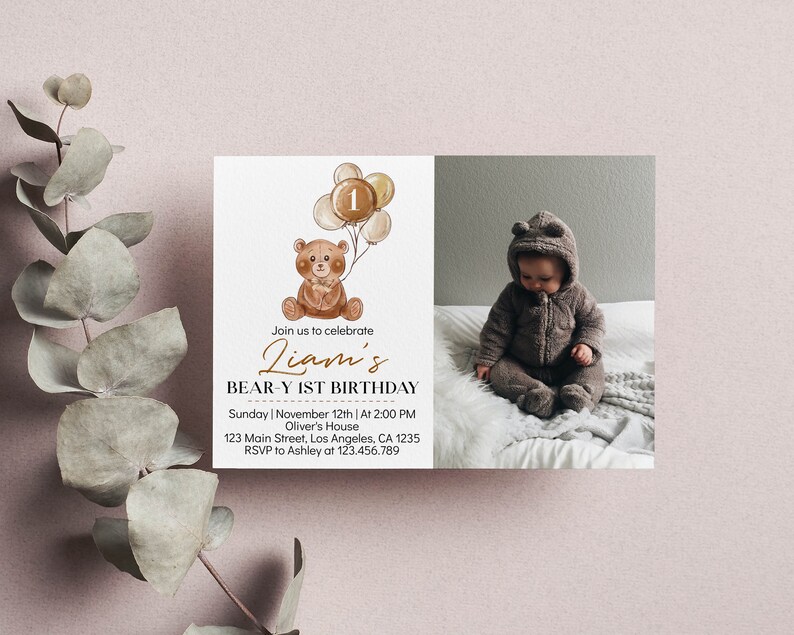 Op de afbeelding: Een rechthoekige verjaardagsuitnodiging met een aquarelillustratie van een bruine teddybeer die beige ballonnen met het cijfer 1 vasthoudt. De tekst luidt: Join us to celebrate Liam's BEAR-Y 1ST BIRTHDAY, Sunday, November 12th, 2:00 PM.
