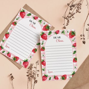 May include: Two rectangular stationery sheets featuring a pink and white gingham border decorated with watercolor strawberries, green leaves, and small white flowers. Each sheet has an arched white center with black lines and the text Dear Olivia.