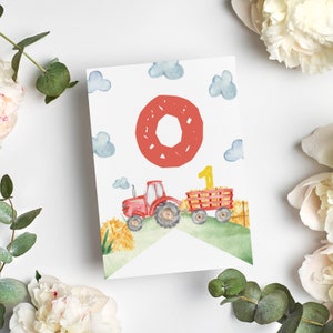 Puede incluir: Una tarjeta rectangular con una ilustraci&oacute;n en acuarela de un tractor rojo tirando de un remolque lleno de heno. Una letra O roja grande se sit&uacute;a sobre el tractor y un n&uacute;mero 1 amarillo est&aacute; en el remolque bajo un cielo con nubes azules.