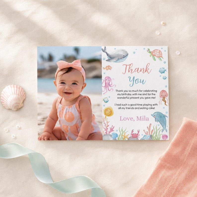 May include: A rectangular thank you card featuring a photo of a smiling baby wearing a peach headband and a patterned romper on the left, and watercolor sea creatures with the text Thank You, Love, Mila on the right side.