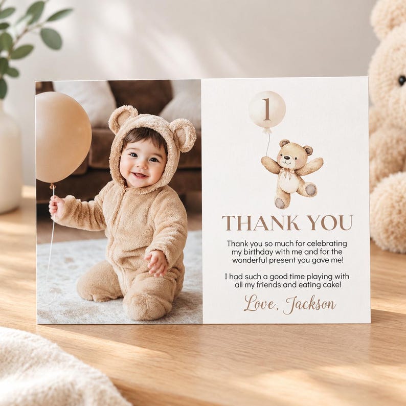May include: A rectangular thank you card featuring a photo of a baby in a tan bear-ear jumpsuit holding a beige balloon. The right side displays a watercolor illustration of a teddy bear with a balloon, the number 1, and the text Thank You.