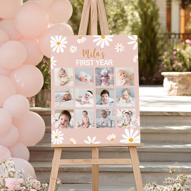 May include: A rectangular sign with a light pink background featuring white daisy illustrations and the text Mila's FIRST YEAR. The sign displays a grid of twelve individual photographs of a baby at different stages of their first year.