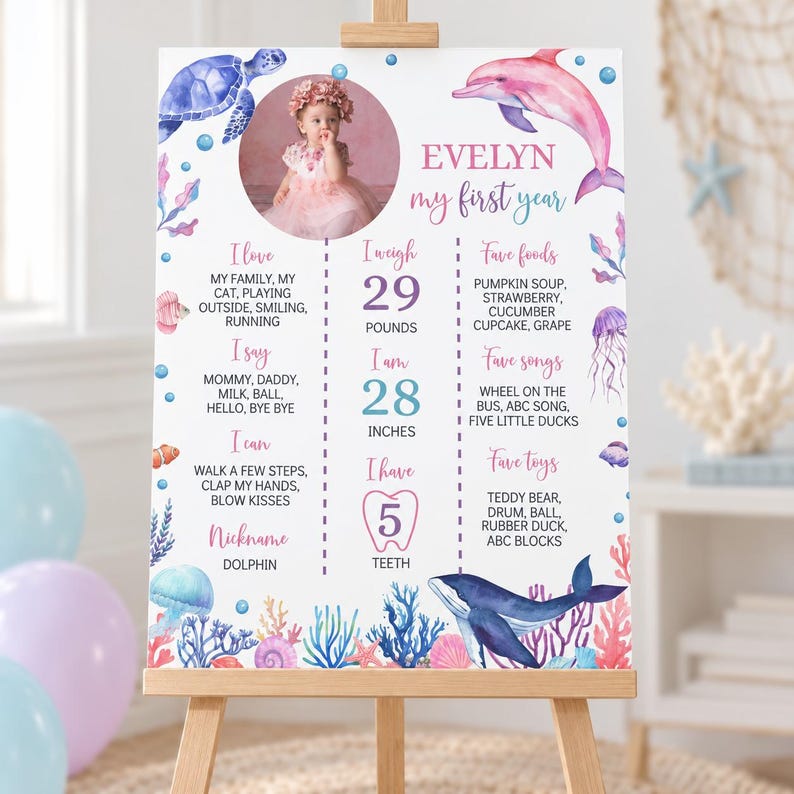 May include: A white milestone birthday sign featuring a circular photo of a child, watercolour sea creatures including a turtle, dolphin, and whale, and text detailing personal facts like 29 pounds, 28 inches, and 5 teeth in pink and blue.