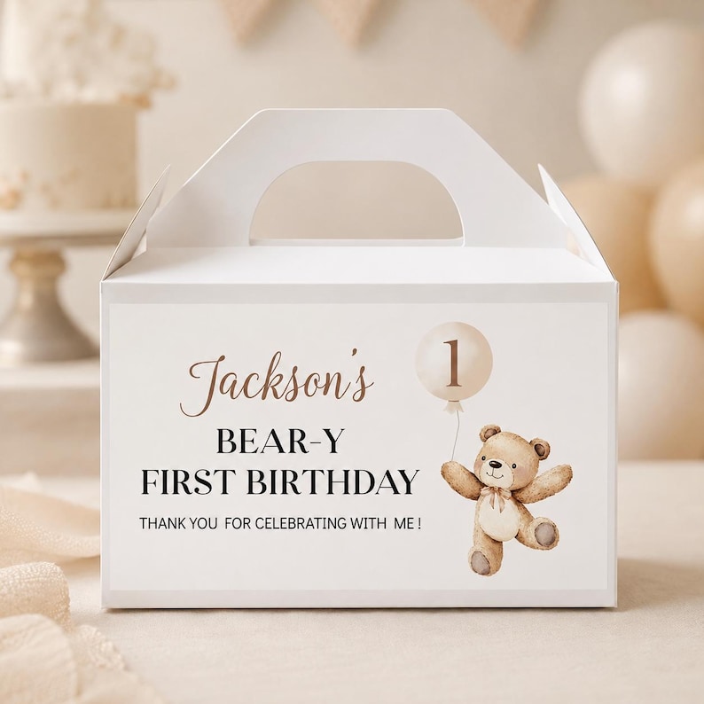May include: A white cardboard gable box featuring a printed design with the text Jackson's BEAR-Y FIRST BIRTHDAY THANK YOU FOR CELEBRATING WITH ME! and an illustration of a brown teddy bear holding a beige balloon with the number 1 inside.
