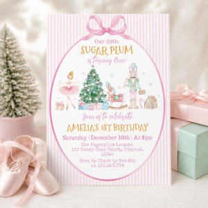 May include: A rectangular birthday invitation card with a pink and white striped background and a pink bow at the top. The center features a ballerina, a Christmas tree, a rocking horse, and a nutcracker with text reading Our little SUGAR PLUM is turning One! Join us to celebrate AMELIA'S 1ST BIRTHDAY Saturday December 10th At 2pm The Sugarplum Lounge 123 Candy Cane Court, Toyland. 12345 RSVP to Clara by Dec 8th at 123.456.789.