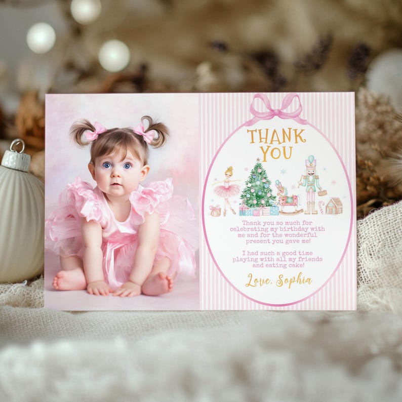 May include: A rectangular thank you card featuring a photograph of a toddler in a pink ruffled dress on the left and a pink striped background with a gold oval frame on the right. The frame contains a Christmas tree, a nutcracker, and text.