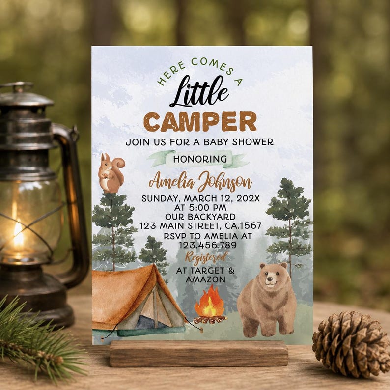 Op de afbeelding: Een uitnodigingskaart voor een babyshower met een bosthema, een bruine tent, een kampvuur, een eekhoorn en een beer. De tekst luidt: Here Comes A Little Camper, Join Us For A Baby Shower Honoring Amelia Johnson, zondag 12 maart 202X.