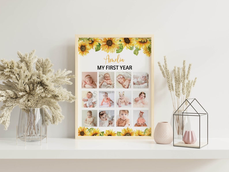 Może przedstawiać: Oprawiony kolaż zdjęć z dwunastoma zdjęciami dziecka, z napisem "Amelia MY FIRST YEAR". Rama jest ozdobiona ż&oacute;łtymi słonecznikami. Kolaż jest wyświetlany na białej powierzchni z elementami dekoracyjnymi.