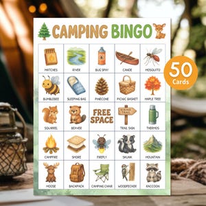 May include: A Camping Bingo game card with illustrations of camping-related items like a campfire, canoe, and thermos. The card features the text "CAMPING BINGO" and "50 Cards". The illustrations are in a watercolor style.