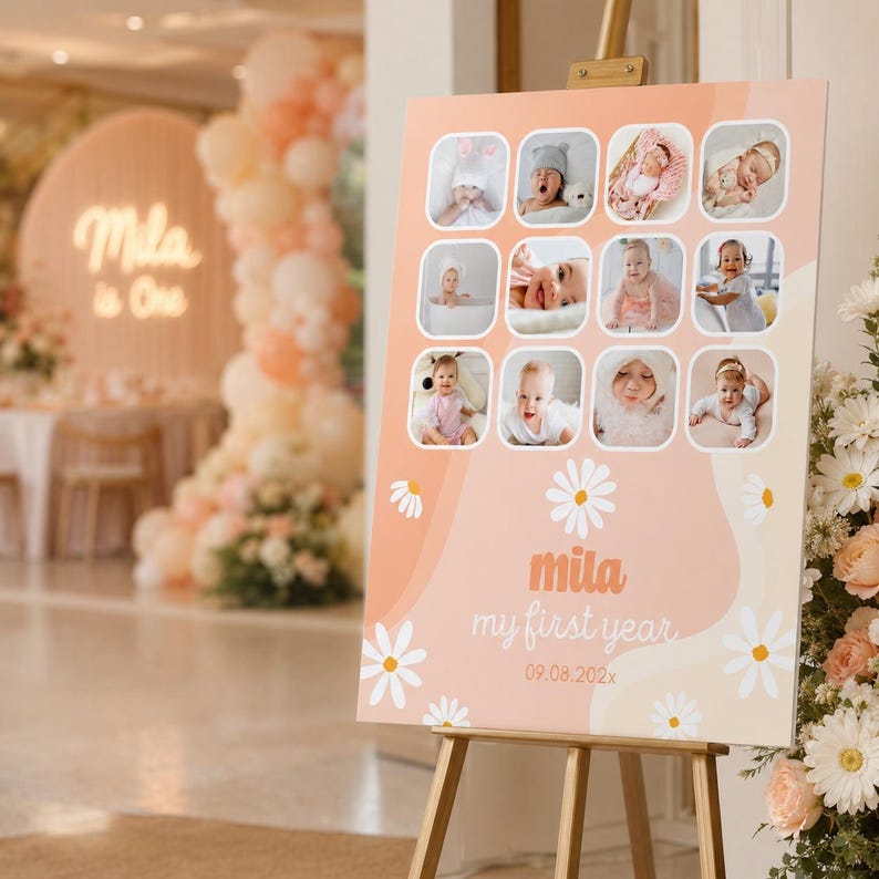 May include: A peach-colored sign on a wooden easel, featuring a collage of baby photos. The sign has a daisy and wave design, with the text "mila my first year" and the date 09.08.202x. The background includes party decorations.