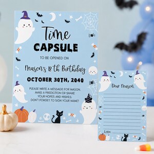 May include: A light blue time capsule sign and matching lined message card for Mason's 18th birthday on October 30th, 2040. The stationery features illustrations of ghosts in purple hats, black cats, pumpkins, spiderwebs, and candy on a light blue background.