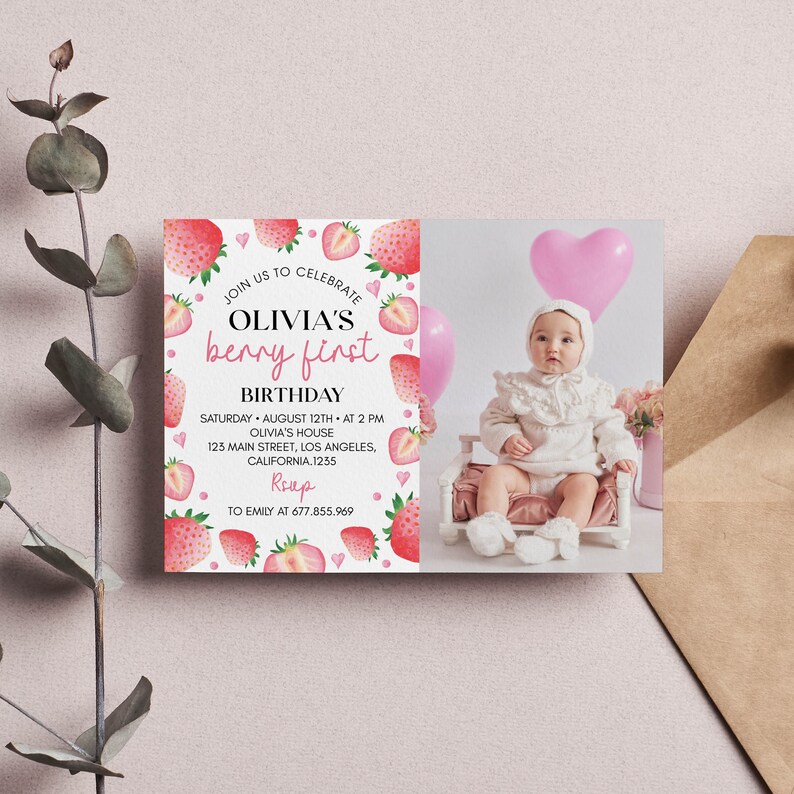 May include: A rectangular birthday invitation card featuring a white background with watercolor strawberry illustrations and pink hearts. The text reads: JOIN US TO CELEBRATE OLIVIA'S berry first BIRTHDAY, SATURDAY AUGUST 12TH AT 2 PM, OLIVIA'S HOUSE, 123 MAIN STREET, LOS ANGELES, CALIFORNIA.1235, RSVP TO EMILY AT 677.855.969. A photograph of a baby in a white outfit sits on the right side.