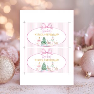May include: Two rectangular labels with a light pink vertical striped background. Each label features a pink oval frame with a bow, containing the text Sophia's WINTER ONEDERLAND in pink and gold, with illustrations of a ballerina, tree, and nutcracker.