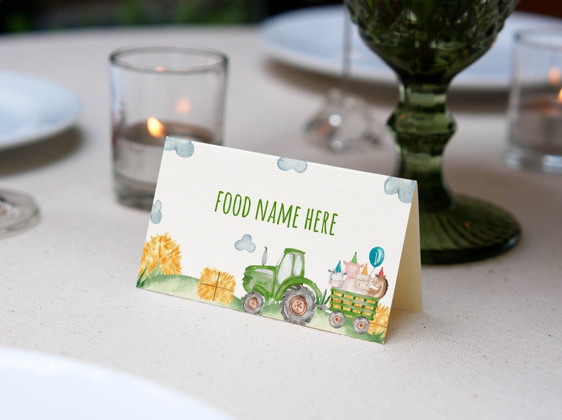 May include: A green tractor with a bale of hay in the back, pulling a wagon with farm animals wearing party hats. The text "FOOD NAME HERE" is printed on the card.