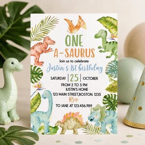 Op de afbeelding: Een rechthoekige verjaardagsuitnodigingskaart met aquarelillustraties van diverse dinosaurussen en tropische bladeren. De tekst luidt: ONE A-SAURUS, Join us to celebrate Justin's 1st birthday, SATURDAY 25 OCTOBER, FROM 2 TO 5 PM, JUSTIN'S HOME, 123 MAIN STREET, BOSTON. 1235, RSVP TO JANE AT 123.456.789.
