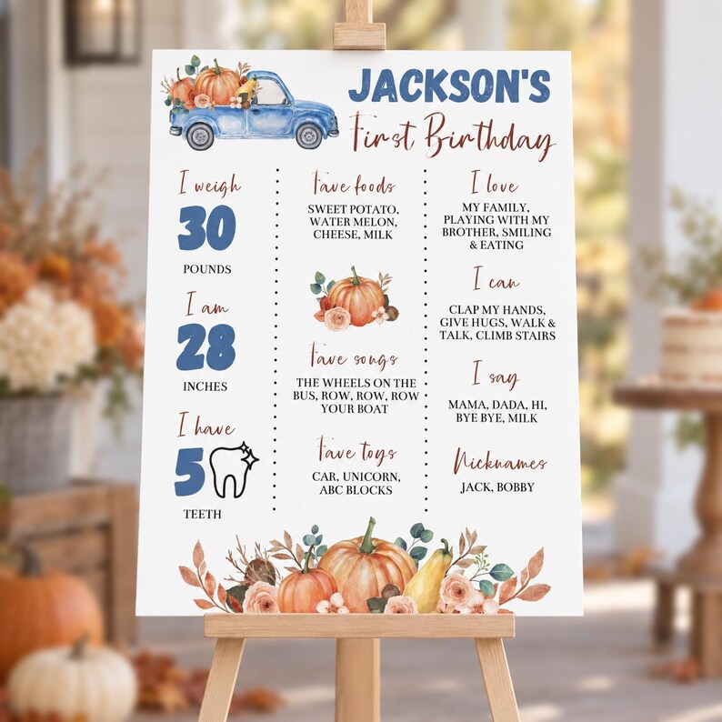 May include: A white birthday milestone sign featuring a blue truck carrying pumpkins, with text reading Jackson's First Birthday, listing stats like 30 pounds, 28 inches, 5 teeth, favorite foods, songs, toys, loves, can do, says, and nicknames.