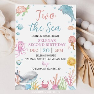 May include: A blue and pink invitation card with the text "Two the Sea" and a sea-themed design. The invitation is for Selena's second birthday party on December 20th at 2 PM. The address is 123 Main Street, Las Vegas, 1235. RSVP to Emma at 123.456.789.