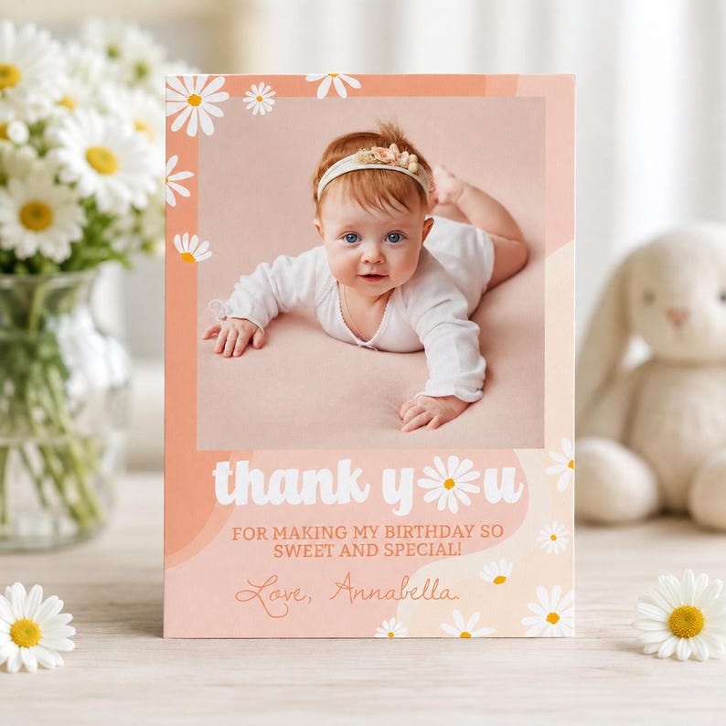 May include: A rectangular thank you card featuring a photo of a baby wearing a white long-sleeve shirt and a floral headband. The card has a peach background with white daisy illustrations and the text: thank you FOR MAKING MY BIRTHDAY SO SWEET AND SPECIAL! Love, Annabella.