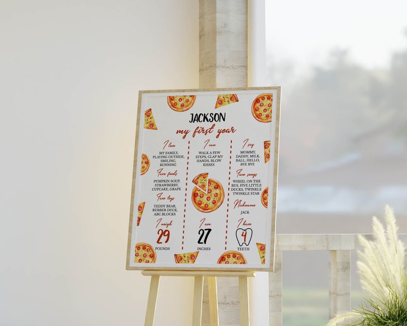 May include: A white and red printable first birthday milestone poster with a pizza theme. The poster features a list of things the child loves, favorite foods, favorite toys, and their measurements in pounds and inches. The poster also includes a graphic of a pizza slice with a red heart in the center.