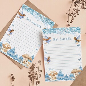 May include: Two sheets of lined stationery featuring a blue winter forest theme with illustrations of fairies, butterflies, and mushroom houses. The top of each page includes the printed text Dear Amanda and the bottom includes the printed text Love.