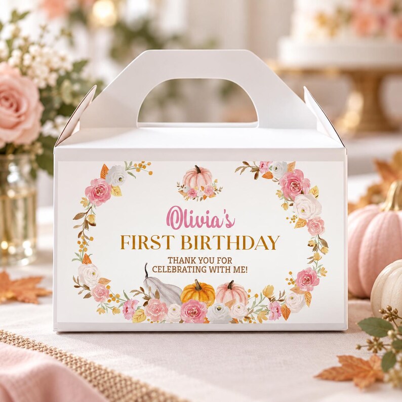 May include: A white cardboard gable box featuring a floral wreath design with pink and white roses, orange and white pumpkins, and the text "Olivia's FIRST BIRTHDAY THANK YOU FOR CELEBRATING WITH ME!" printed in pink and gold on the front panel.