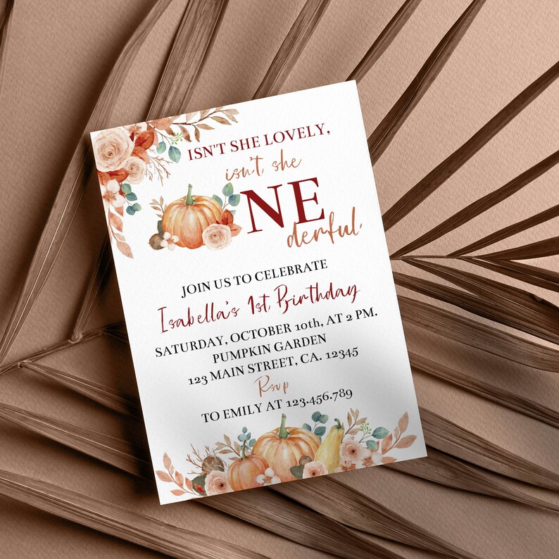 May include: A rectangular birthday invitation card featuring watercolour illustrations of orange pumpkins, beige roses, and autumn leaves. The text reads: ISN'T SHE LOVELY, isn't she ONEderful, JOIN US TO CELEBRATE Isabella's 1st Birthday, SATURDAY, OCTOBER 10th, AT 2 PM.